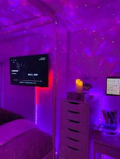 a bedroom with purple lighting and a flat screen tv