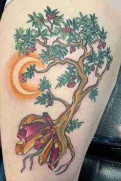 a woman's thigh with a tree and bow on it