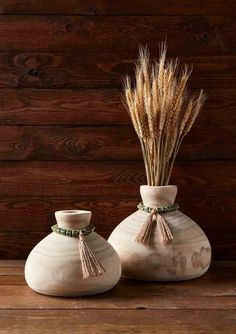 two white vases with dried grass in them