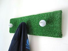 a golf ball is on the green grass next to a coat rack and towel holder