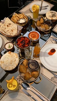 a table filled with plates and silverware covered in different types of food on top of it