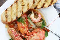 a white plate topped with seafood and bread