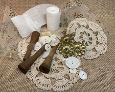 sewing supplies laid out on a doily with lace, buttons and other things to sew