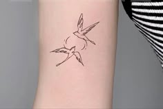 a small bird tattoo on the left side of the right arm is shown in black ink