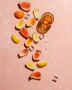 some pieces of fruit that have been cut in half and are sitting on a pink surface