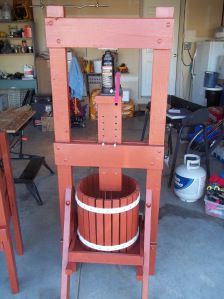 a wooden chair sitting next to a bucket on top of a table in a garage