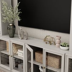 a white entertainment center with baskets and vases