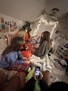 a group of women sitting on top of a bed next to each other in a room