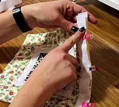 a person is cutting fabric with scissors on the floor