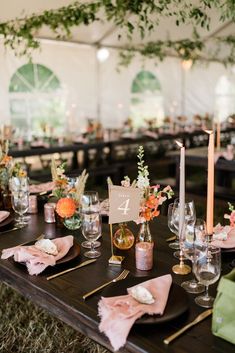 the table is set with candles, plates and napkins for an elegant wedding reception