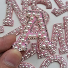 someone is holding up some letters made out of pearls