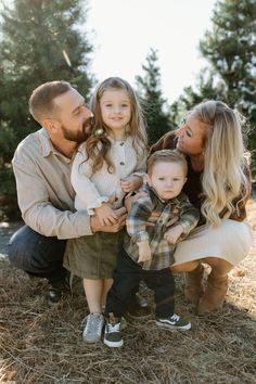 a family poses for a photo in front of some trees