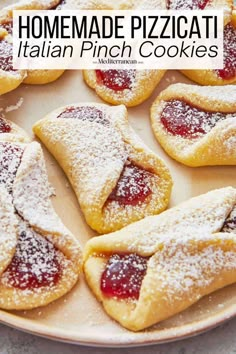 homemade pizzeria italian pinch cookies on a plate with powdered sugar and jelly