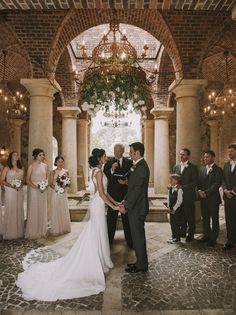 a bride and groom standing in front of their wedding party