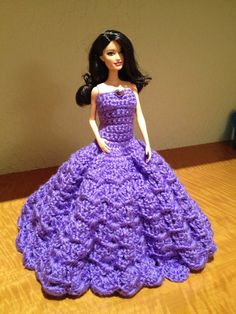 a barbie doll wearing a purple crocheted dress