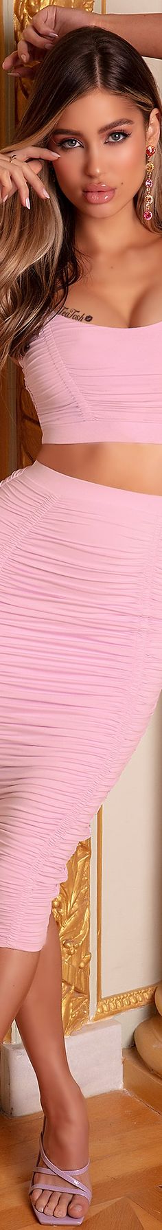 a woman in a pink dress is posing for the camera with her hair blowing back