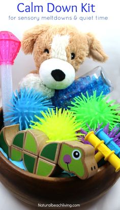 a teddy bear sitting on top of a wooden bowl filled with toys and other items