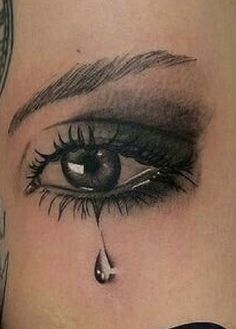 a woman's face with a teary eye tattoo on her side, and the bottom part of her lower lip