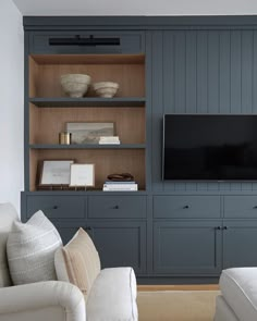 a living room filled with furniture and a flat screen tv on top of a wooden entertainment center