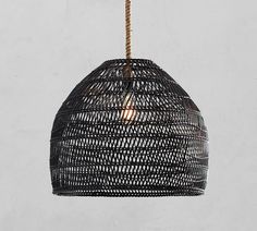 a black rattan light hanging from a rope