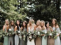 a group of women standing next to each other wearing dresses and holding bouquets in their hands