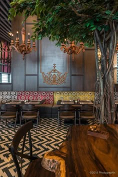 the interior of a restaurant with tables, chairs and chandeliers hanging from the ceiling