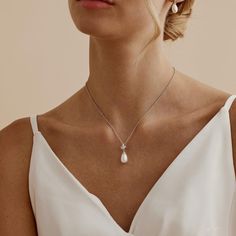 💎  Make your special day even more unforgettable with our Sterling Silver Freshwater Pearl Diamond Necklace! This elegant necklace features a timeless blend of freshwater pearls, shimmering diamonds, and a delicate leaf crystal design. 🌿✨ 👰  Whether you're the bride or a bridesmaid, this necklace is the perfect finishing touch for any wedding ensemble. The soft glow of the pearls and the sparkle of diamonds create a stunning look that is both classic and modern. 💫 💖  Each necklace is meticu Minimalist White Pearl Bridal Necklace, Pear-shaped White Gold Pearl Wedding Necklace, Delicate Silver Bridal Necklace With Pearl Pendant, Elegant Pear-shaped Silver Pearl Necklace, Formal Silver Pear-shaped Pearl Necklace, Crystal Wedding Necklace, Dainty Pearl Necklace, Necklace Leaf, Pearl And Diamond Necklace