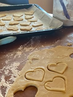 two pans filled with heart shaped cookies on top of a table