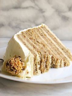 a slice of cake with white frosting and sprinkles on a plate