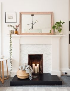 a living room with a fire place and some pictures on the wall above it,