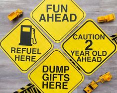 four yellow caution signs sitting on top of a wooden floor