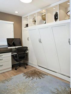 a home office with white cabinets and drawers