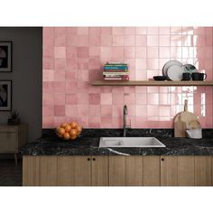 a kitchen with pink tiles on the wall and wooden cabinets, along with bookshelves