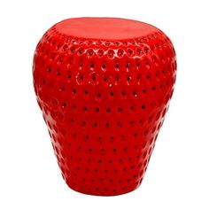 a red ceramic stool with black dots on the top and bottom, sitting in front of a white background