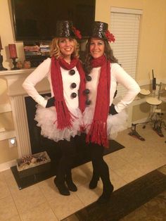 two women dressed up as snowmen posing for a photo in front of a fireplace