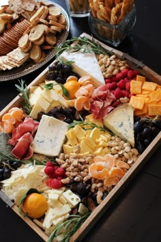 an assortment of cheeses and meats on a platter at a buffet table