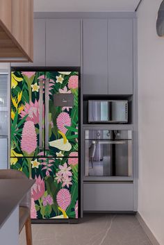 a kitchen with an open refrigerator covered in pink and green floral wallpaper, along with stainless steel appliances