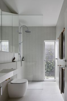 a modern bathroom with white tile walls and floor