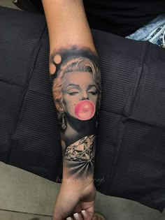 a woman's arm with a tattoo on it that has a pink bubble coming out of her mouth