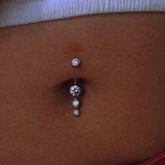 a woman's belly with three diamond studs attached to the back of her stomach