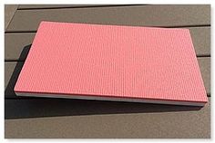 a pink notebook sitting on top of a wooden table