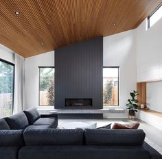 a living room with a couch, fireplace and large windows