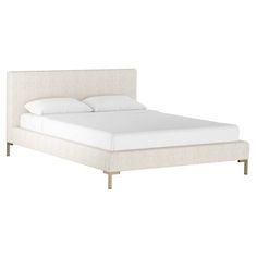 the bed is made up with white linens and gold metal legs on each side