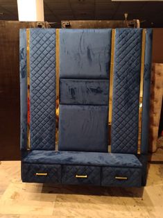 an upholstered blue bench with gold trimmings on the back and sides