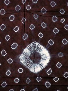 an abstract painting with white circles and squares on dark brown paper, which has been drawn by hand