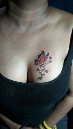 a woman's breast with a butterfly tattoo on her left shoulder and right breast