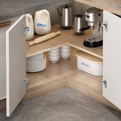 an open cabinet in the corner of a kitchen with dishes and coffee pots on it