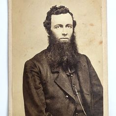 an old black and white photo of a man with a long beard wearing a suit