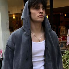 a man in a hoodie is standing outside