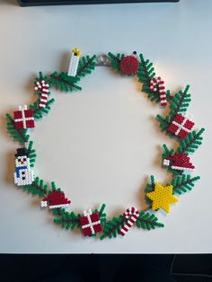 a beaded christmas bracelet with santa clause, holly and snowman decorations on it